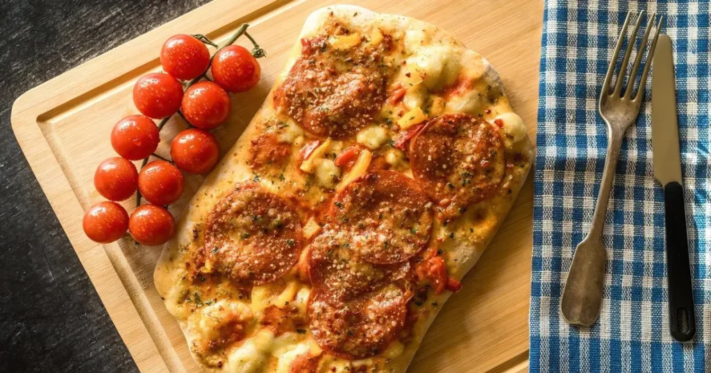 mini pizza com tomate cereja, calabresa e queijo