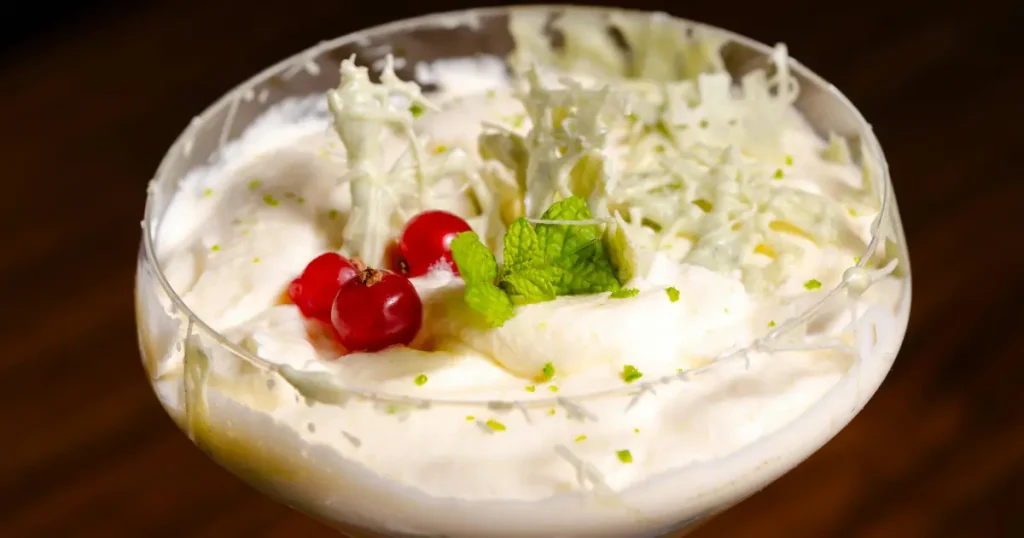 Sobremesa fácil, simples e rápida de mousse de limão com cerejas e folha de hortelã por cima